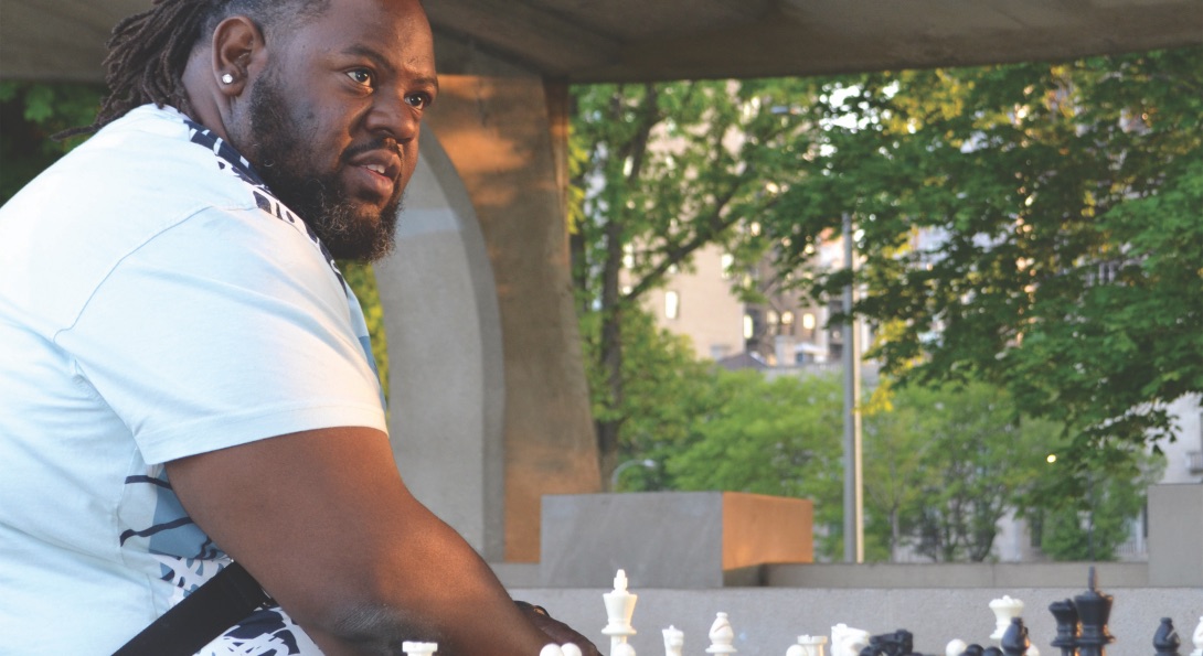 A Black man plays a game of chess at Chicago's lakeshore chess pavilion.