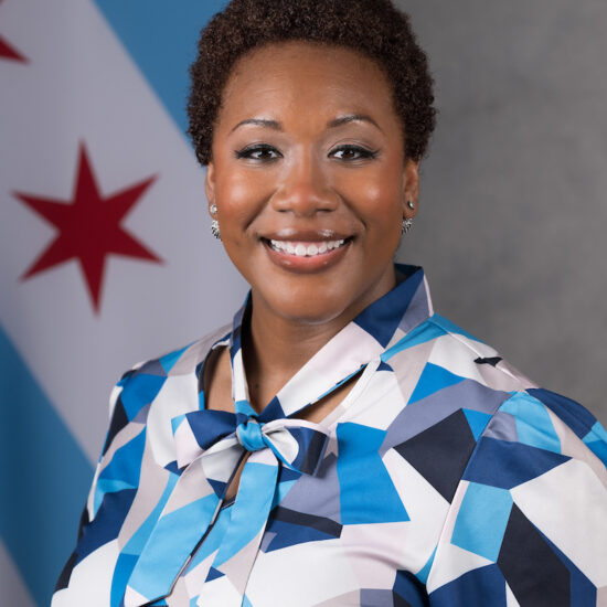 Photo of a professional woman smiling in front of the Chicago flag