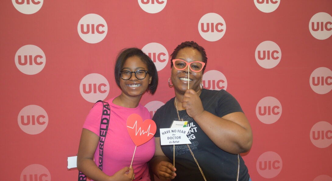 A woman and young girl pose at UIC School of Public Health Photo Booth