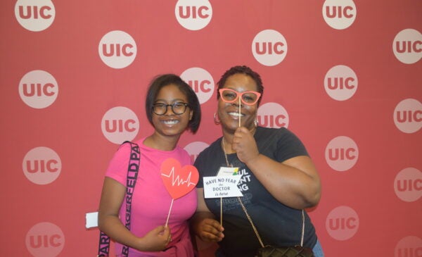 A woman and young girl pose at UIC School of Public Health Photo Booth