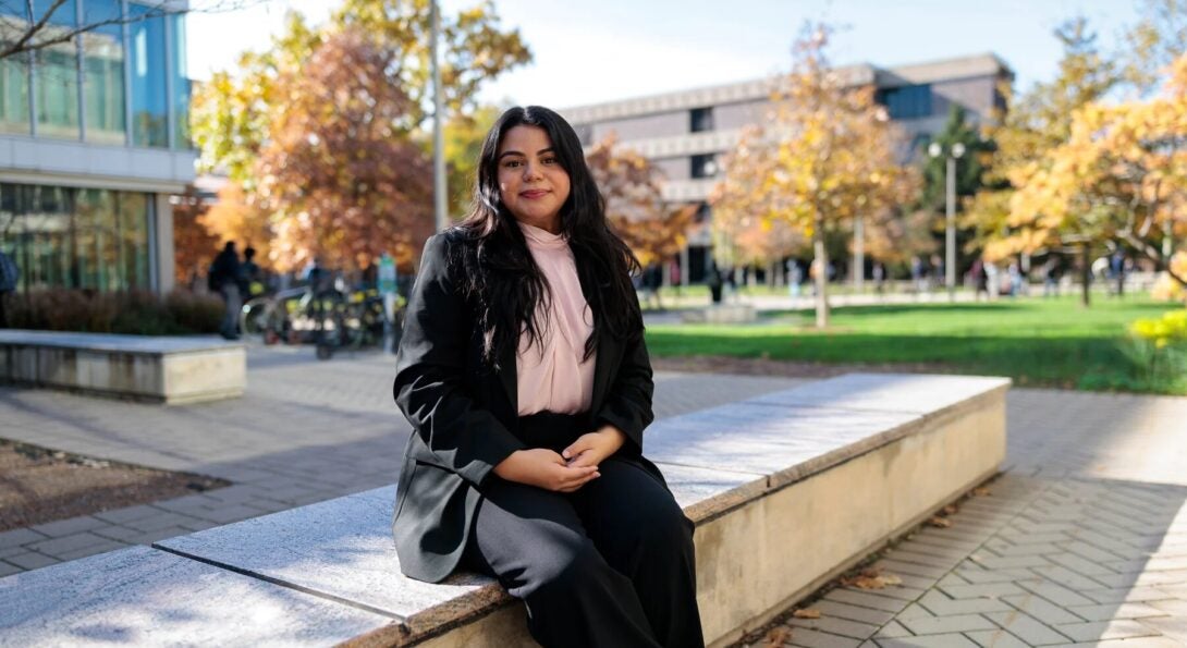 Monica Padilla sits on a stone bench at UIC's campus