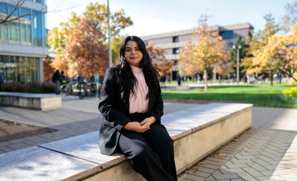 Monica Padilla sits on a stone bench at UIC's campus