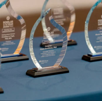 Blue table with six UIC glass flame awards on top 