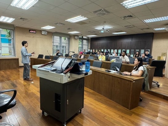 Lecturer in front of a classroom of students.